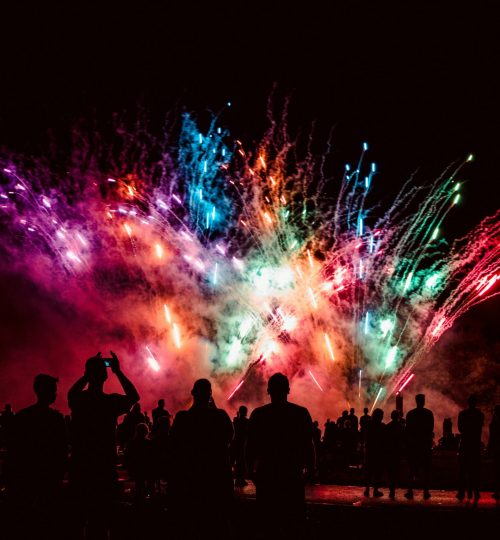 Colorful fireworks light up the night over silhouetted crowd in Dortmund, Germany.